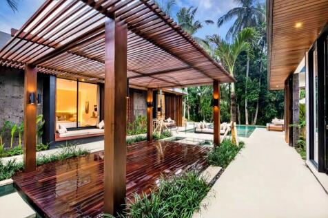 Modern tropical villa with wooden pergolas, lush g