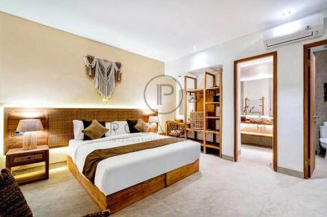 A modern, cozy bedroom with a large bed, warm ligh