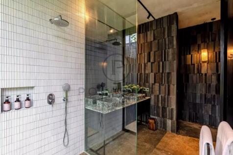 The picture shows a modern bathroom with a glass-e