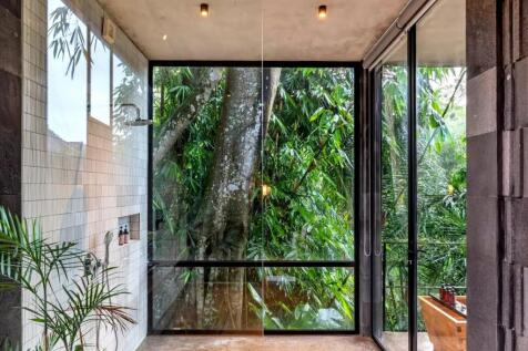 A modern bathroom with large glass windows offers 