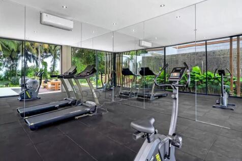 A modern gym with treadmills, stationary bikes, an