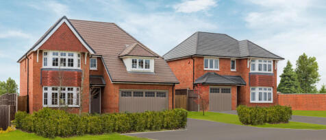 Two modern red-brick houses with grey roofs, white window frames, and surrounding green lawns and tr