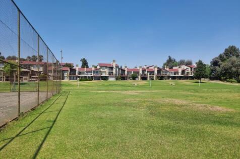 Tennis court with complex in back