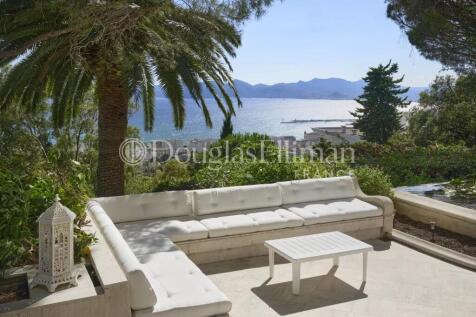A serene terrace with a white sofa set, overlookin