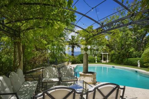 A serene outdoor scene features a lush green pergo