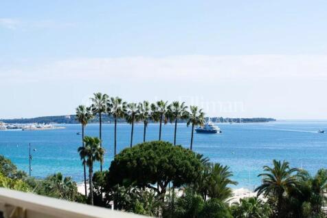 Ocean view with palm trees and boats under a clear