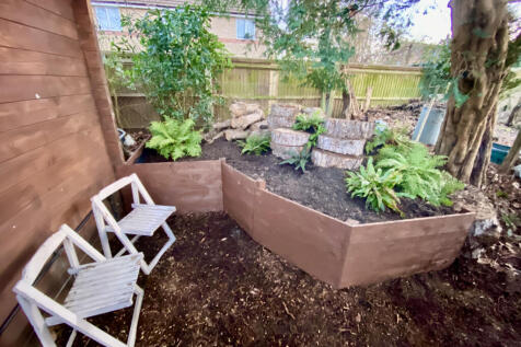 Raised shaded fern Garden to right of log cabin