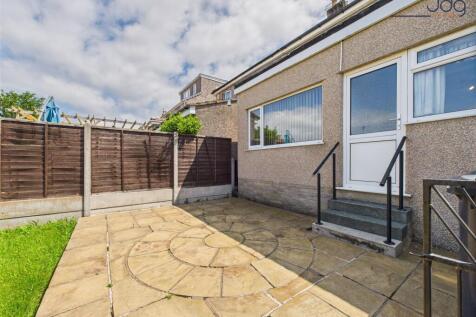 Generously sized garden with a patio and lawn