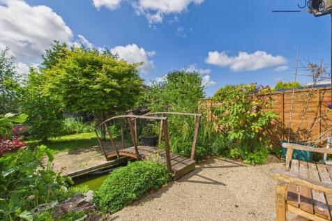 south-facing rear garden with bridge and small pond