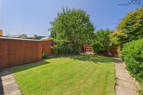 Spacious rear garden with mature plants and boarders