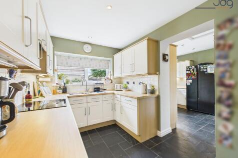 Kitchen flowing openly into a matching utility room