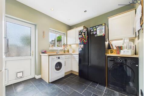 Kitchen flowing openly into a matching utility room