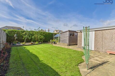 Spacious rear garden with flags and lawn