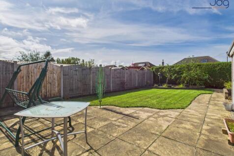 Spacious rear garden with flags and lawn
