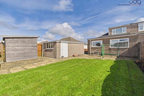 Spacious rear garden with flags and lawn