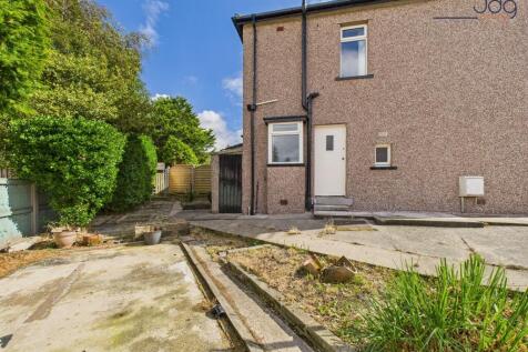 Wrap around garden to the side and the front with mature plant beds, flags and lawn