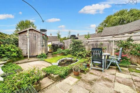 Spacious Flagged Garden with Mature Shrubs and Pond