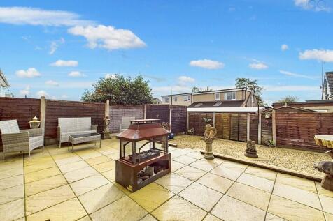 Garden featuring patio, gravel section, shed, and outdoor tap