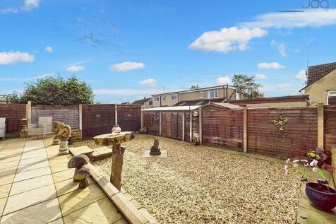 Garden featuring patio, gravel section, shed, and outdoor tap