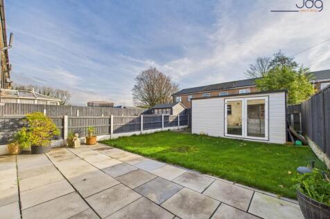 Generous garden combining lawn and paved areas.