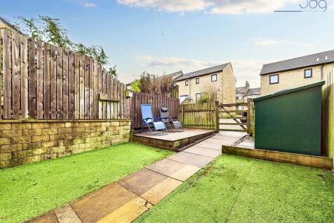South-facing garden, designed for low maintenance, featuring artificial grass and a decked seating area