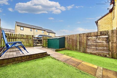 South-facing garden, designed for low maintenance, featuring artificial grass and a decked seating area