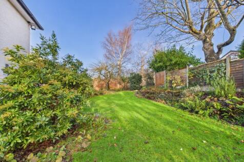 Spacious Garden with a mixture of lawn, mature shrubs, fruit trees and flagstone seating area.