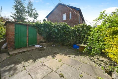 Low maintenance garden to rear, with outbuilding
