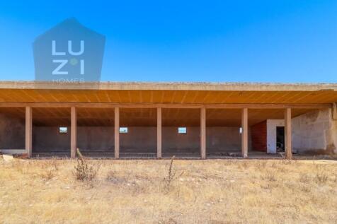 Farm with large urban plot with ruin and extensive flat land, in Burgau - Luzi Homes