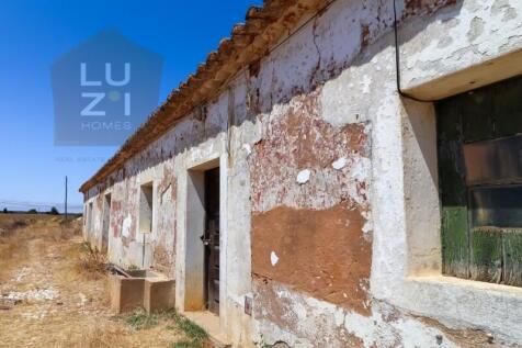 Farm with large urban plot with ruin and extensive flat land, in Burgau - Luzi Homes