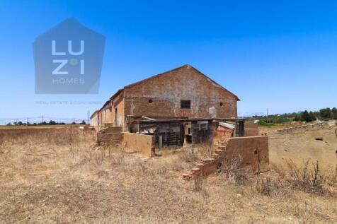 Farm with large urban plot with ruin and extensive flat land, in Burgau - Luzi Homes