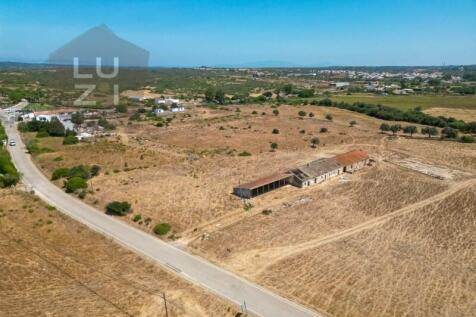 Farm with large urban plot with ruin and extensive flat land, in Burgau - Luzi Homes