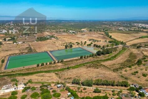 Farm with large urban plot with ruin and extensive flat land, in Burgau - Luzi Homes