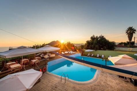 the sun setting behind the pool