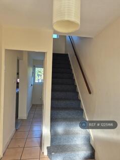 Stairs And Hallway Leading To Utility Space.