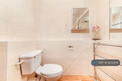 Newly Tiled Toilet With a Large Mirror 