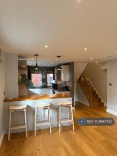 Kitchen And Staircase To Upper Level