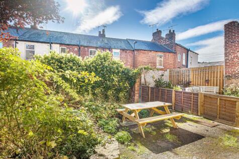 Sunlit private rear garden with a wooden picnic...