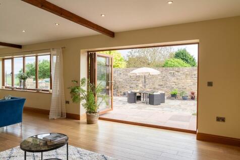 Bi-folds opening onto the sunny courtyard from the bright lounge