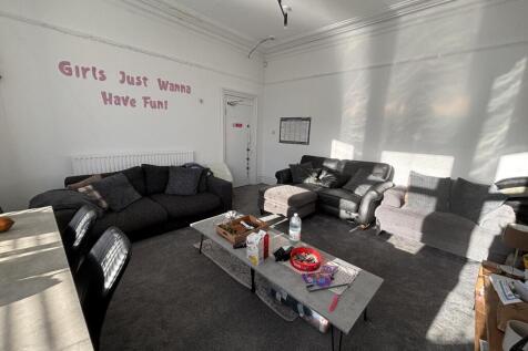 Bright communal lounge with multiple comfortabl...