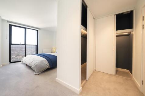 Experience tranquil elegance with a spacious bedroom featuring a sleek walk-in closet.