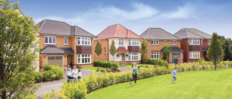 New housing development with modern detached houses, green lawns, and families enjoying the outdoors