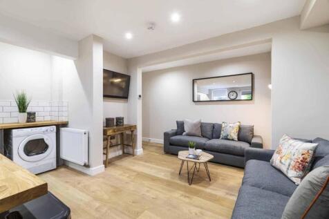 A bright and modern living room featuring ample...