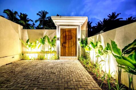 A well-lit entrance with a wooden door, surrounded
