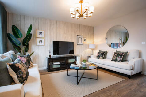 A cozy and stylish living room with a white sofa, a glass coffee table, and a large potted plant