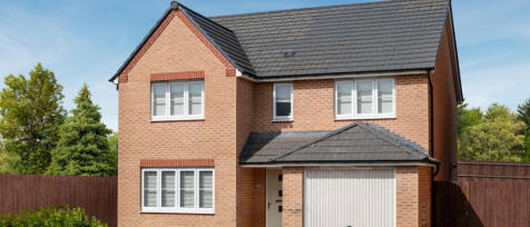 Modern brick house with white-framed windows, grey roof tiles, and a garage, set against a blue sky