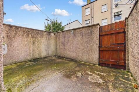Enclosed, low-maintenance rear yard with gated access and potential for improvement.