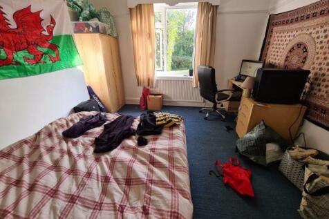 A cozy bedroom featuring a double bed with a ch...