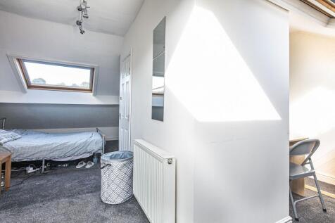 Bright attic bedroom with a skylight, neutral d...
