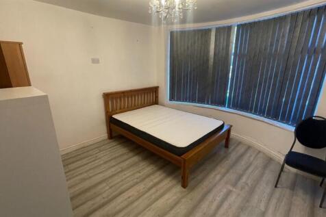 Bright, simply furnished bedroom with a wooden ...